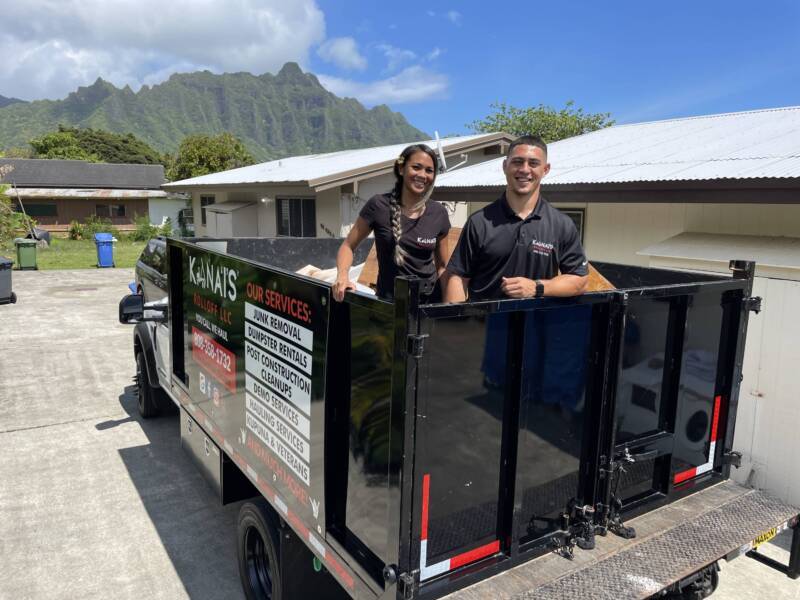 Kana'i's Junk Removal experts posing in a dump truck.