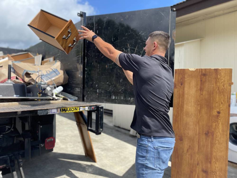 junk removal pro throwing drawer into junk removal truck