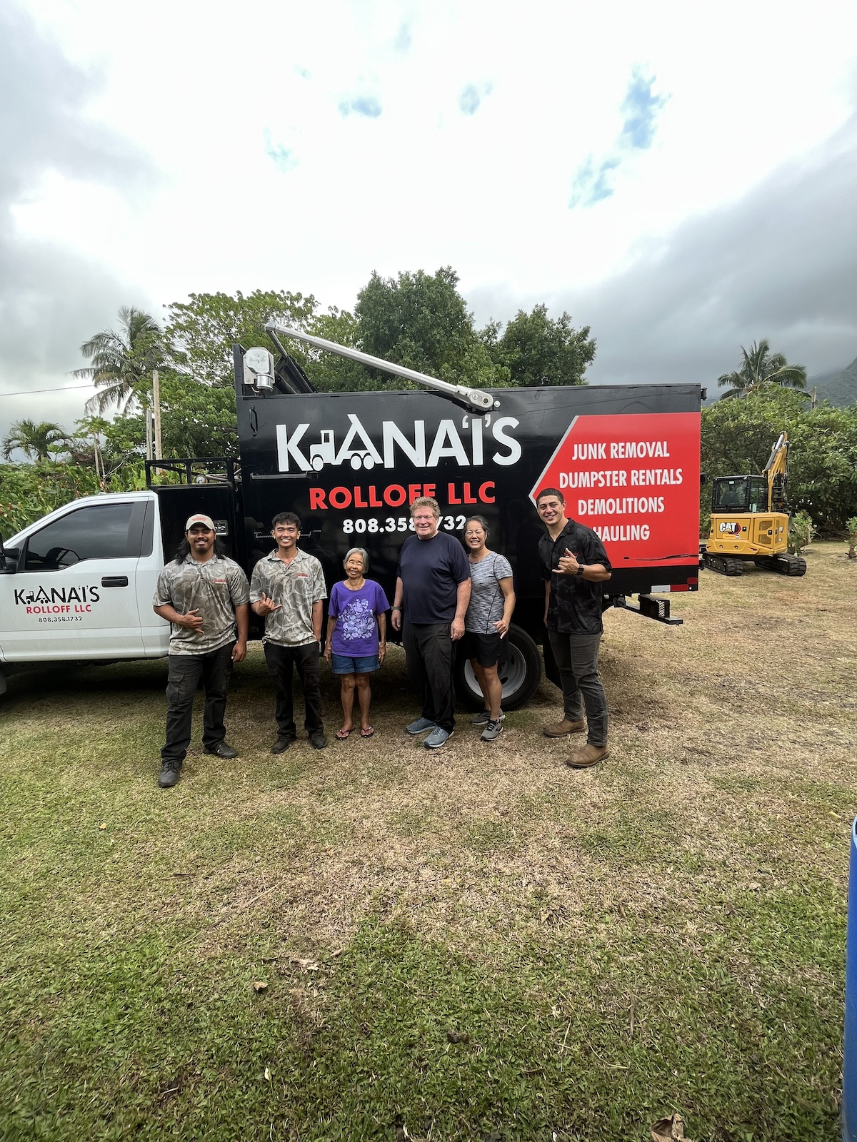 Kana'i's Junk Removal partial team photo standing in front of a company vehicle.