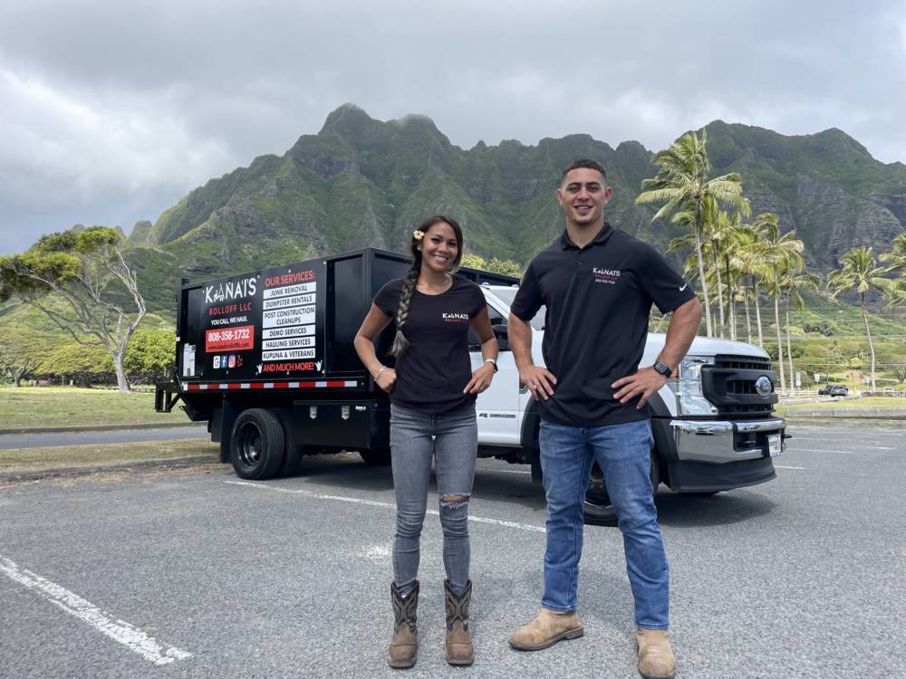 Kana’i Picanco and Brooks Carillo standing in front of one of their junk removal trucks.