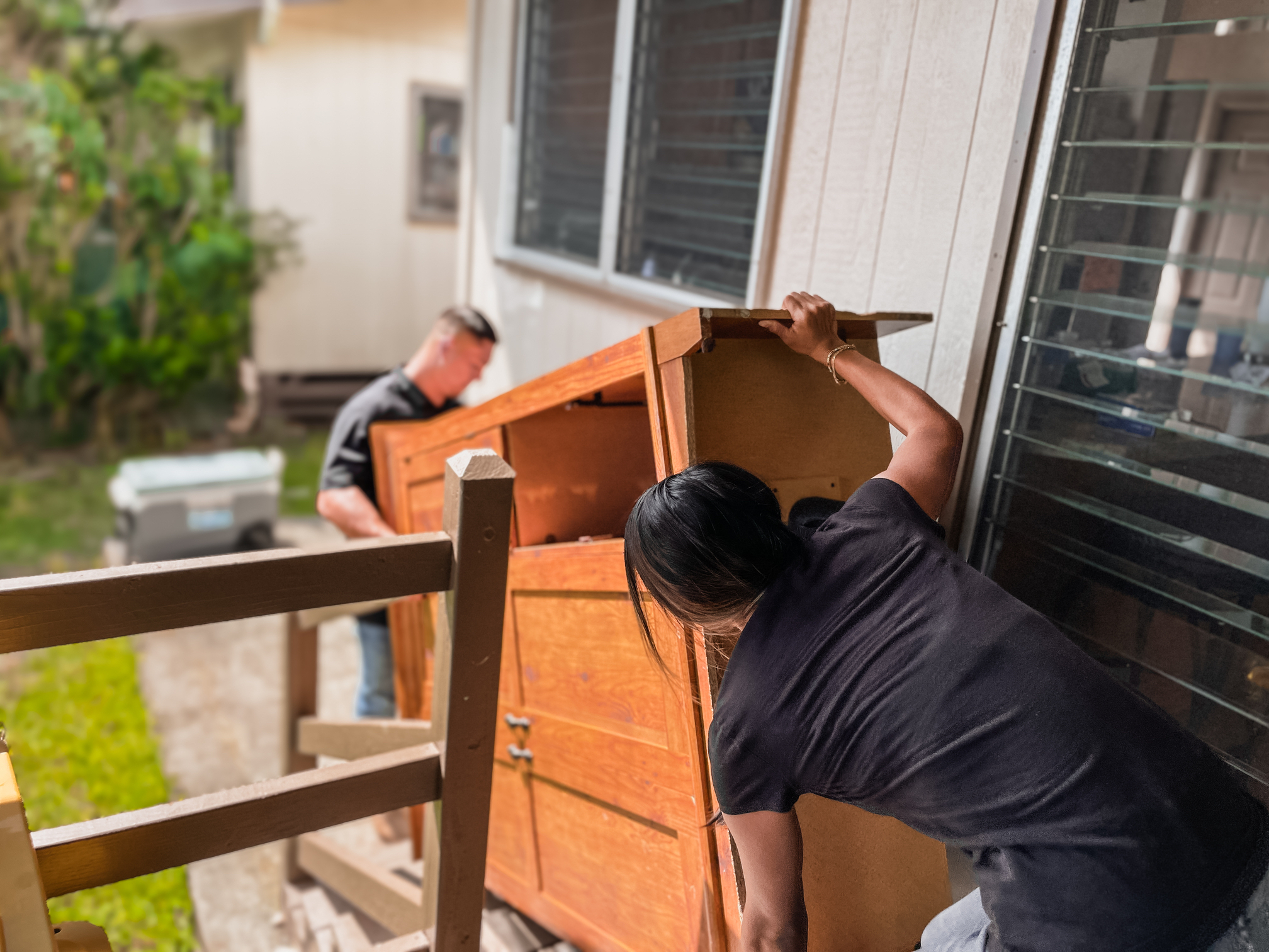 Two of our junk removal workers are carrying a large entertainment center taking it out of an apartment in Oahu.